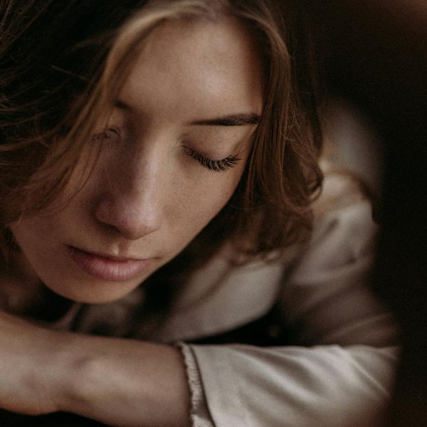Close-up of a person's serene eye with a reflection of a natural landscape.