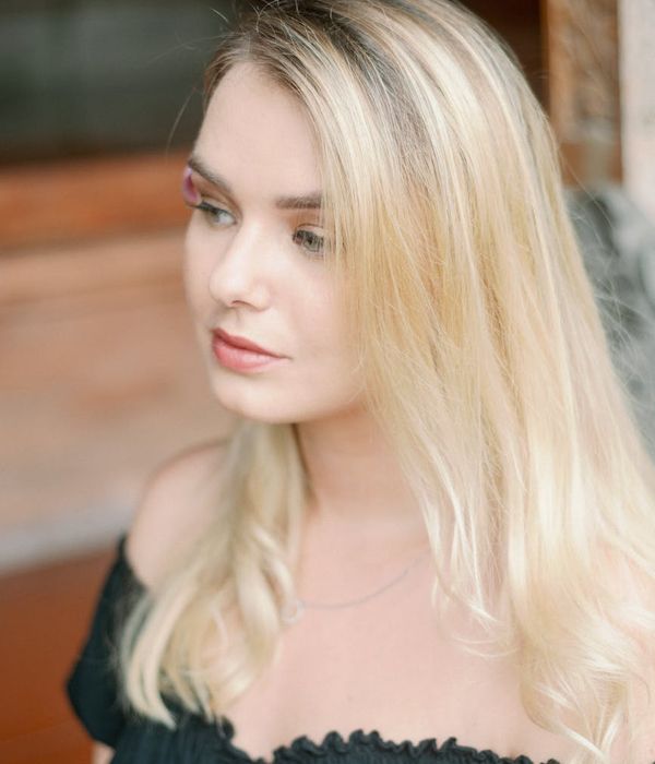 Woman with a calm expression looking into the distance, with cyan light highlighting her features.